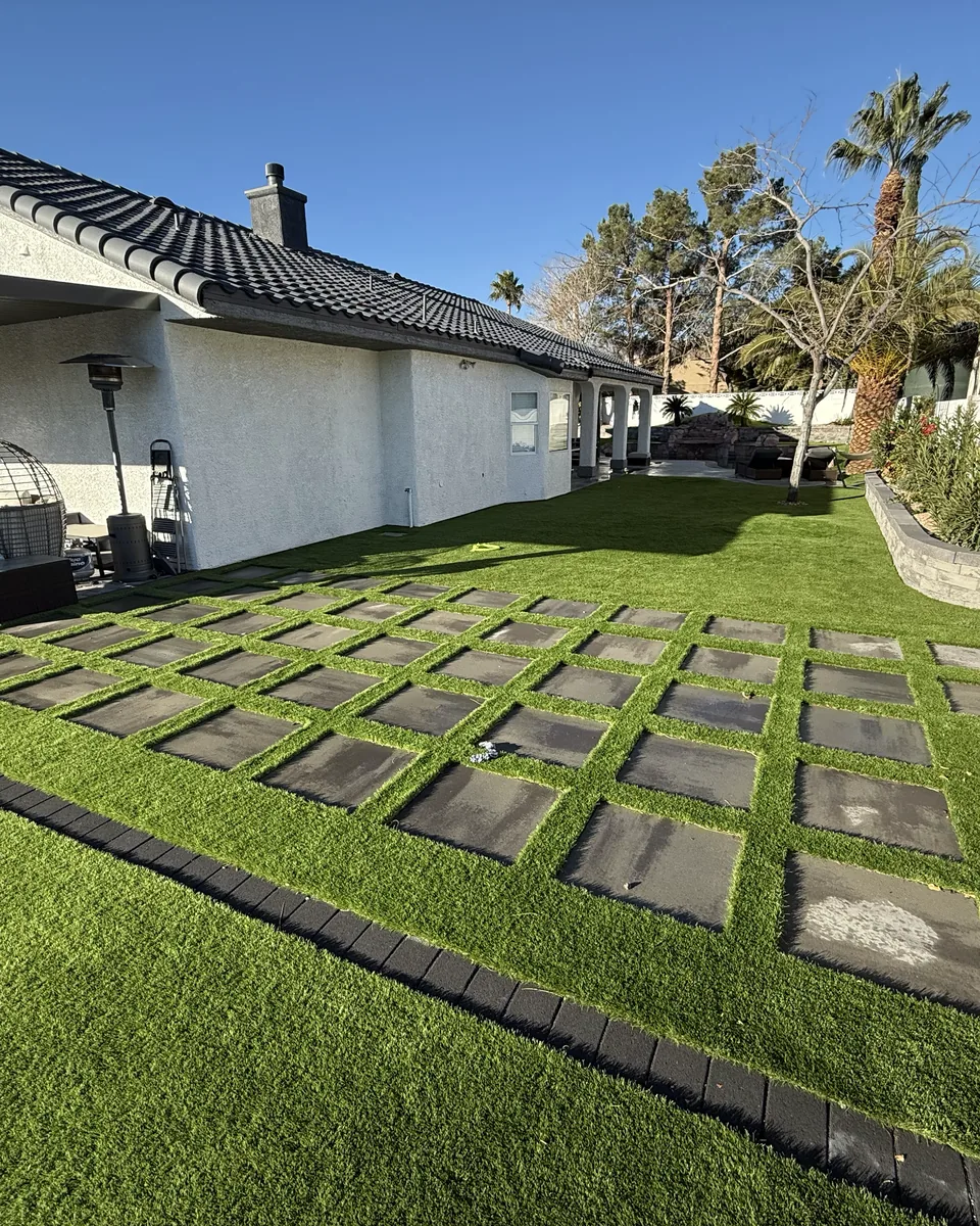 A clean Las Vegas backyard with turf and pavers in late afternoon light.
