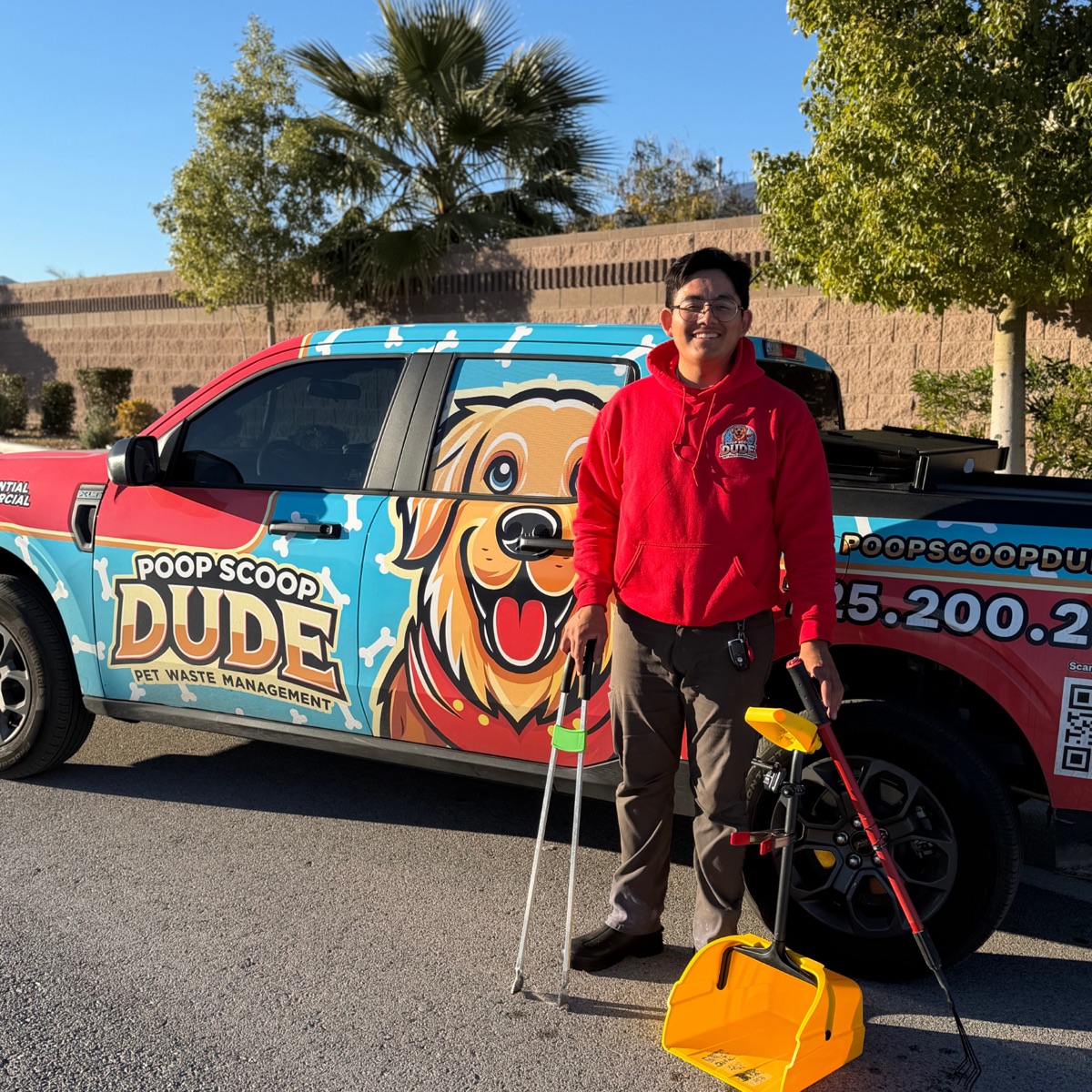 Gianny, founder of Poop Scoop Dude, standing next to the company truck in Las Vegas.